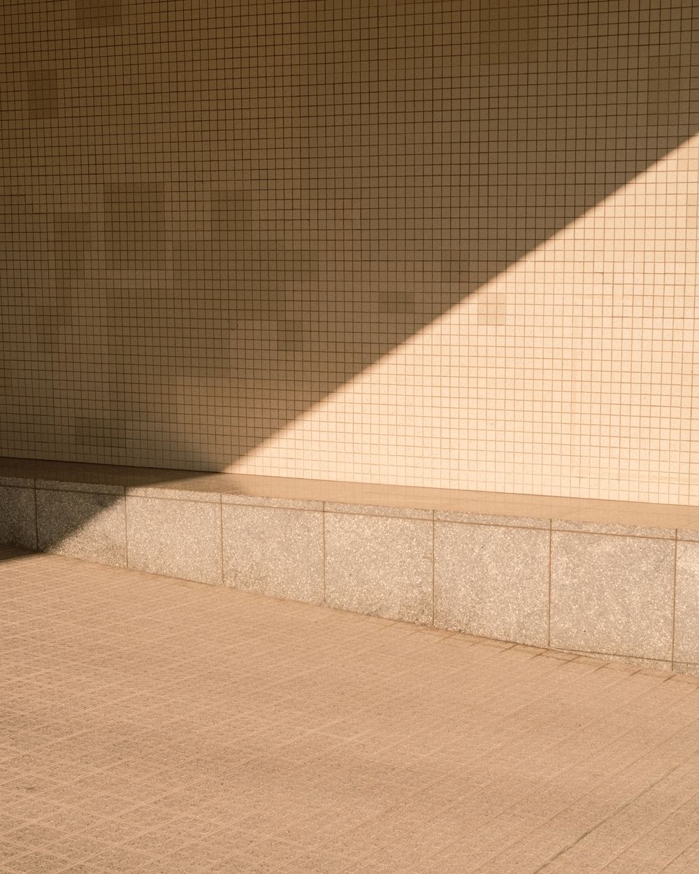 Une lumière dorée qui entre en biais sur un mur clair